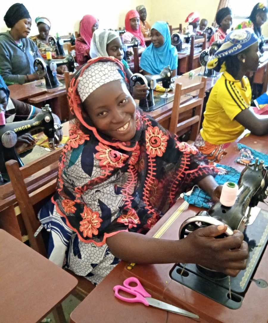 Femme apprenant à utiliser une machine à coudre
